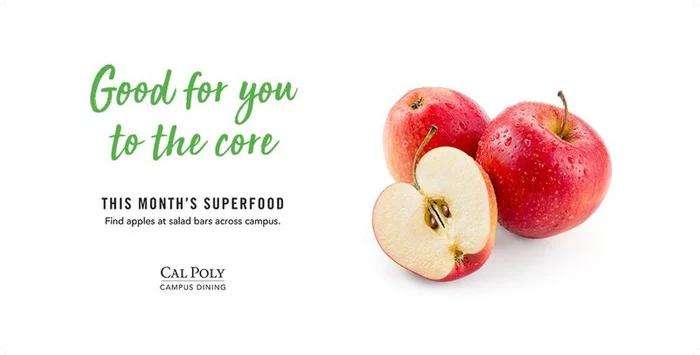 Red apples, one sliced in half, with text promoting apples as this month's superfood at Cal Poly dining.