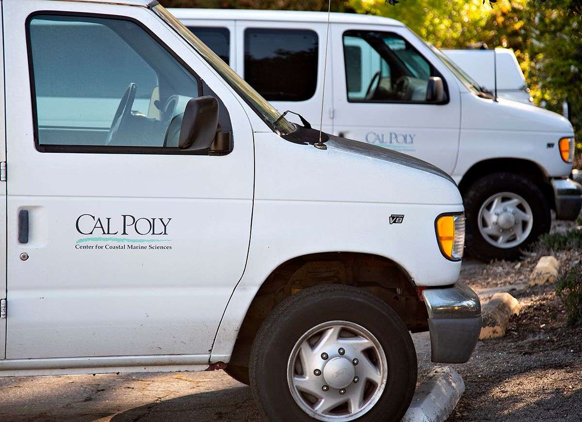 Two white vans parked, each labeled "Cal Poly Center for Coastal Marine Sciences.