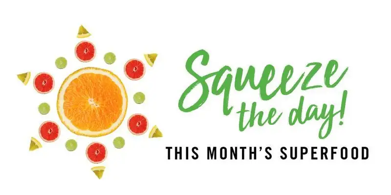 Sun shape made of orange, lime, grapefruit slices and wedges with text "Squeeze the day! This month's superfood