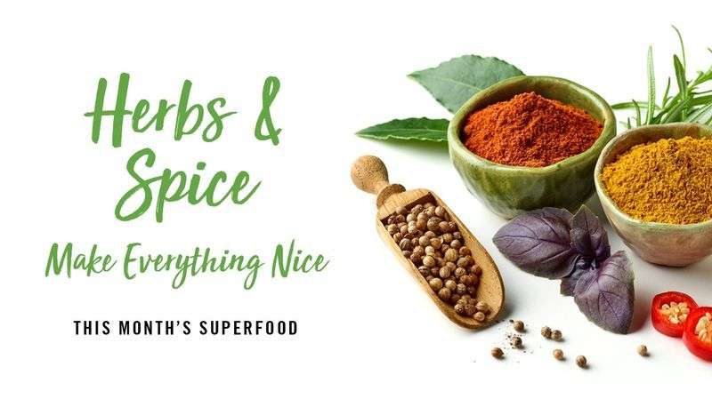 Herbs and spices with bowls of ground spices, coriander seeds, basil, bay leaves, and sliced red chili.